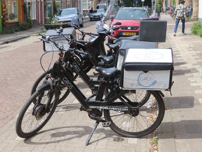 912941 Afbeelding van enkele bezorgfietsen en een bezorgscooter van Grieks restaurant Giros (Abel Tasmanstraat 44) te ...